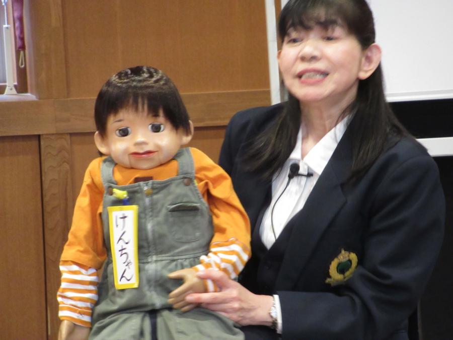 けんちゃんの人形を膝に抱いて腹話術をしている講師の様子