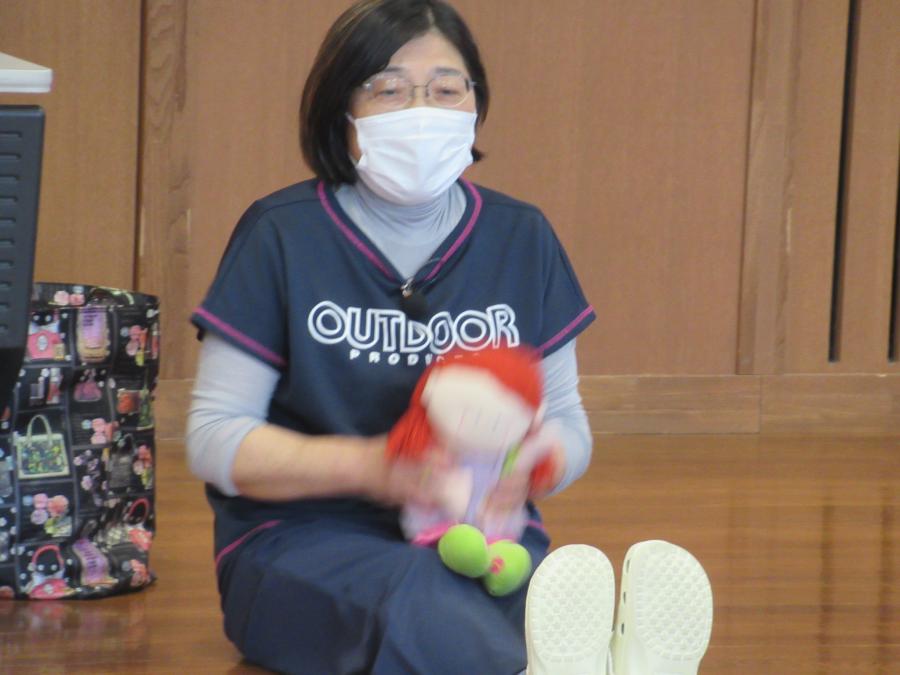 講師が座って人形を持ってやっている様子