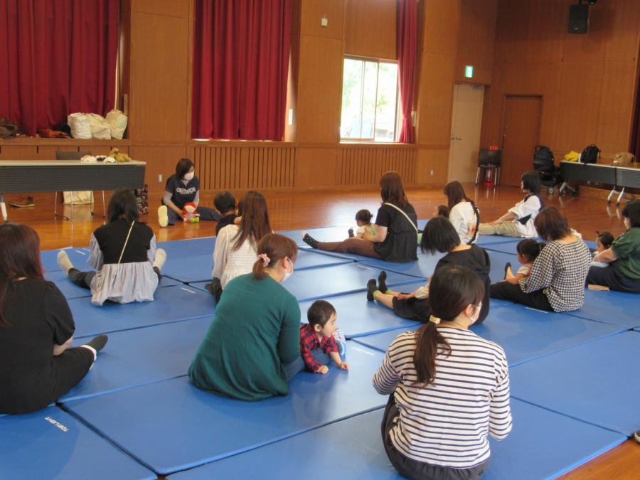 親が座っていて子どもが仰向けに寝ている様子
