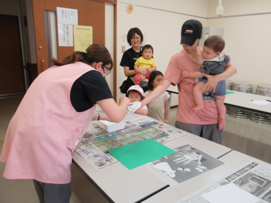 手型を取るために手に白い絵の具をつけて押すところ