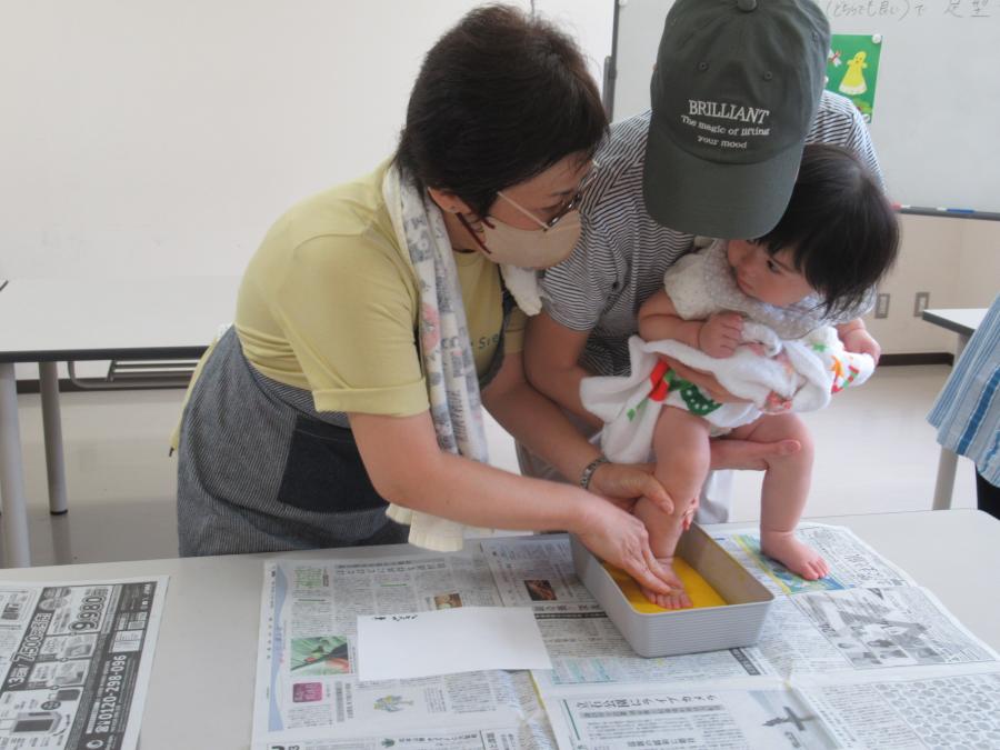 講師に手伝ってもらって足型を取る子どもの様子