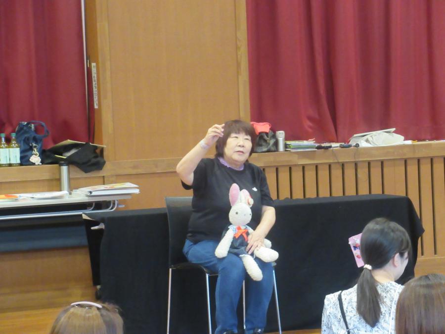 講師の一人がウサギの人形を膝に椅子に座っているところ