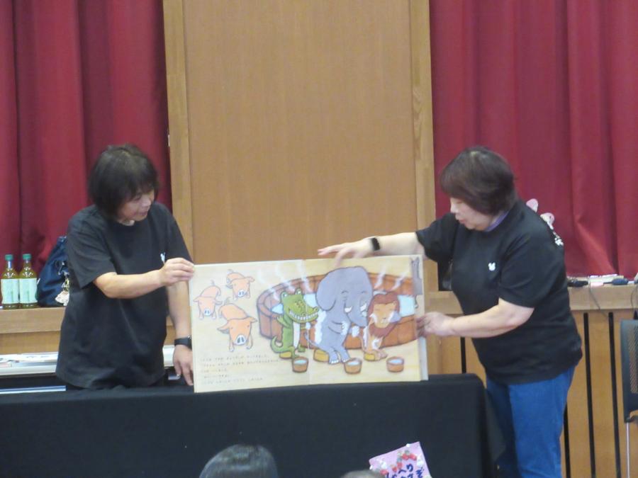 大型絵本を二人の講師が読んでいるところ