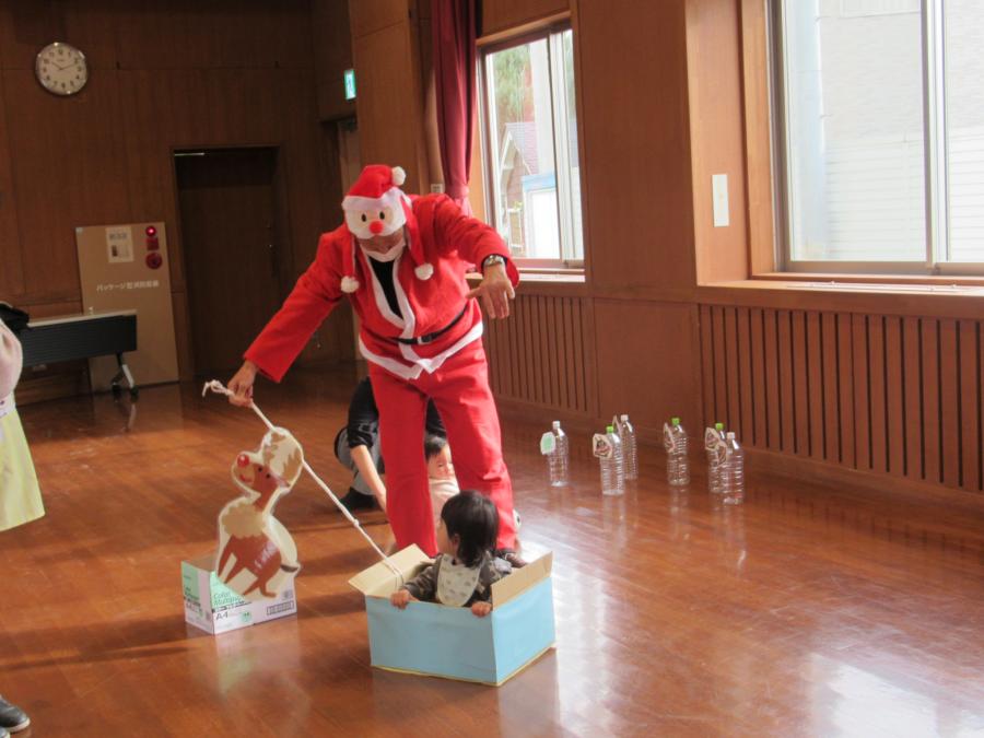サンタクロース館長が子どもを乗せてソリを引っ張る様子