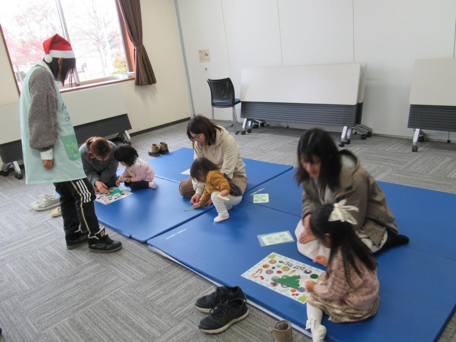 折り紙を折ってツリーを作る親子の写真