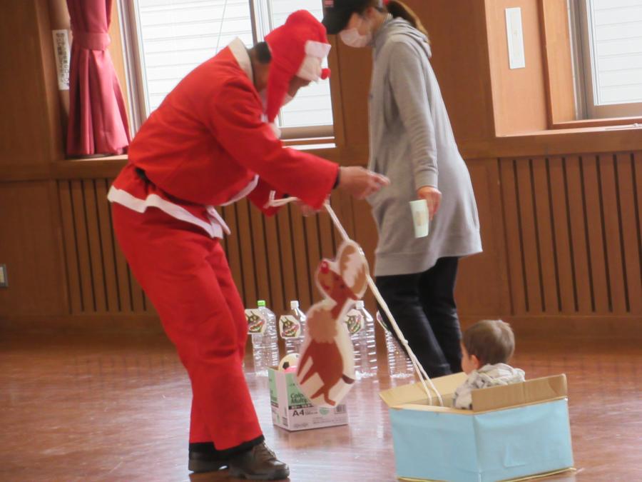 子どもを乗せたソリをサンタクロー引く様子引く様子