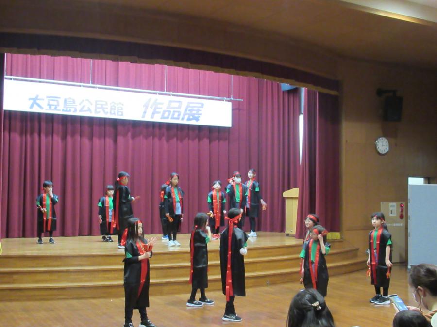 ステージとその下のスペースに分かれてダンスを披露する様子