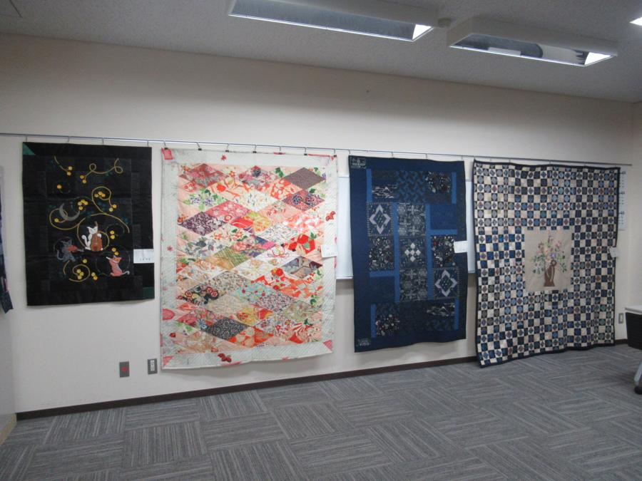 大きなパッチワーク作品が部屋の壁に飾ってある様子