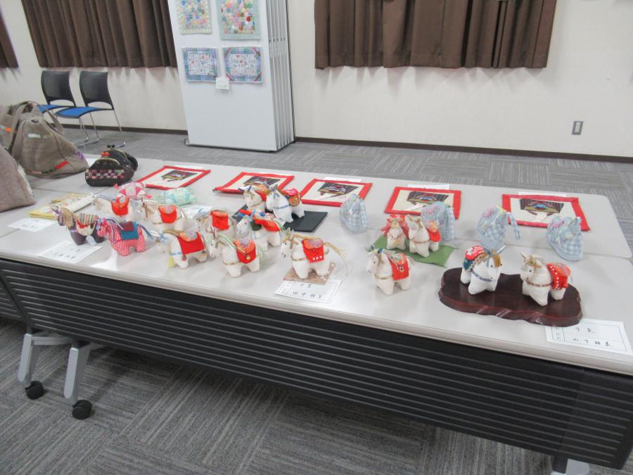 パッチワークの作品を机に並べて展示している様子