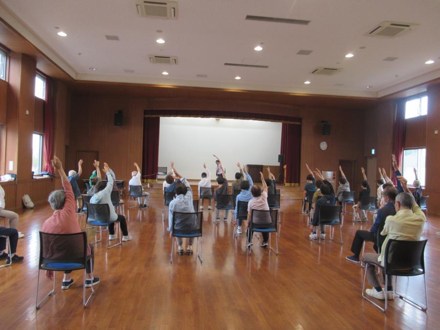 片手を上げ斜めに伸ばしているところ