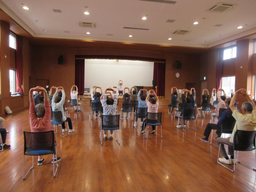 両手を組んで上に上げている運動の様子