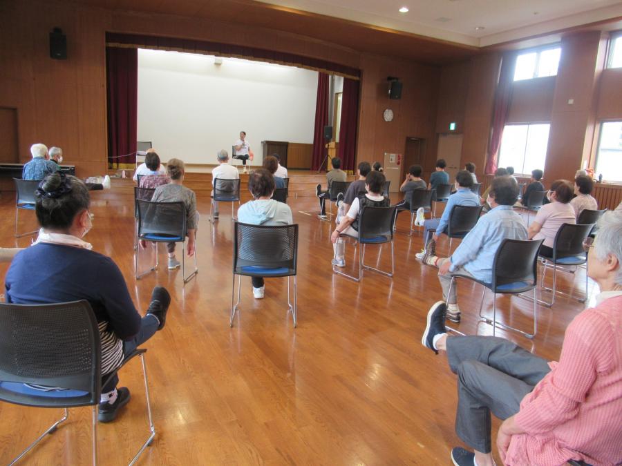 椅子に座り片足を上げて運動している様子