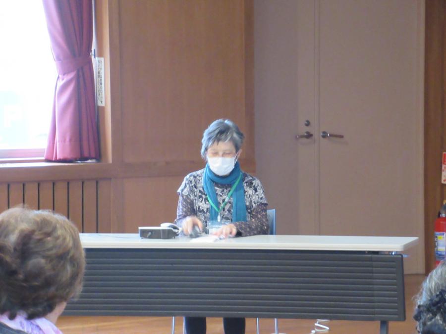 電話機を使って還付金詐欺の対応の実技をしている参加者の女性の写真