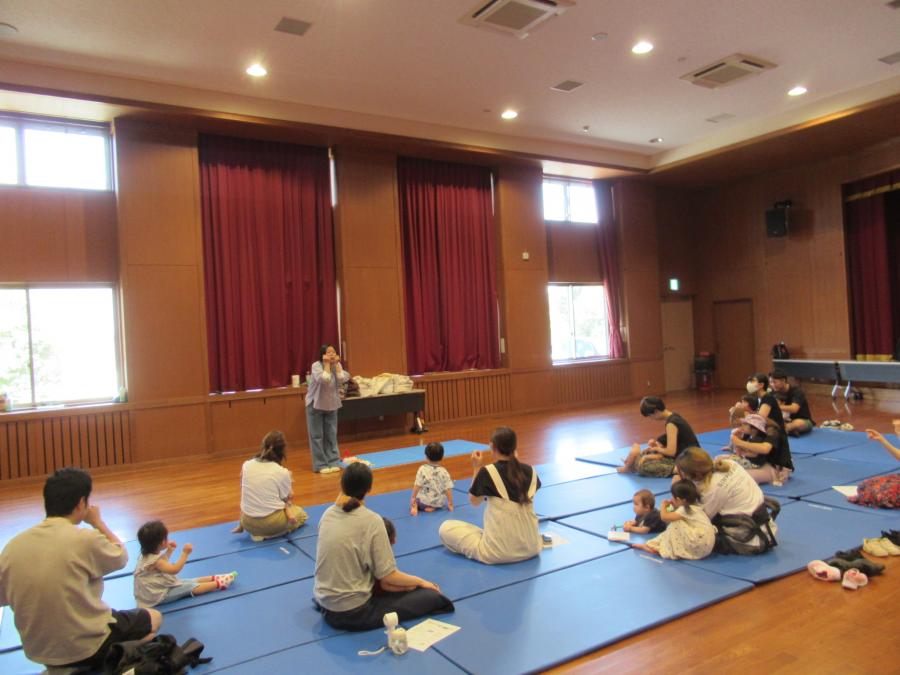 講師と一緒に歌を歌って手遊びしている様子