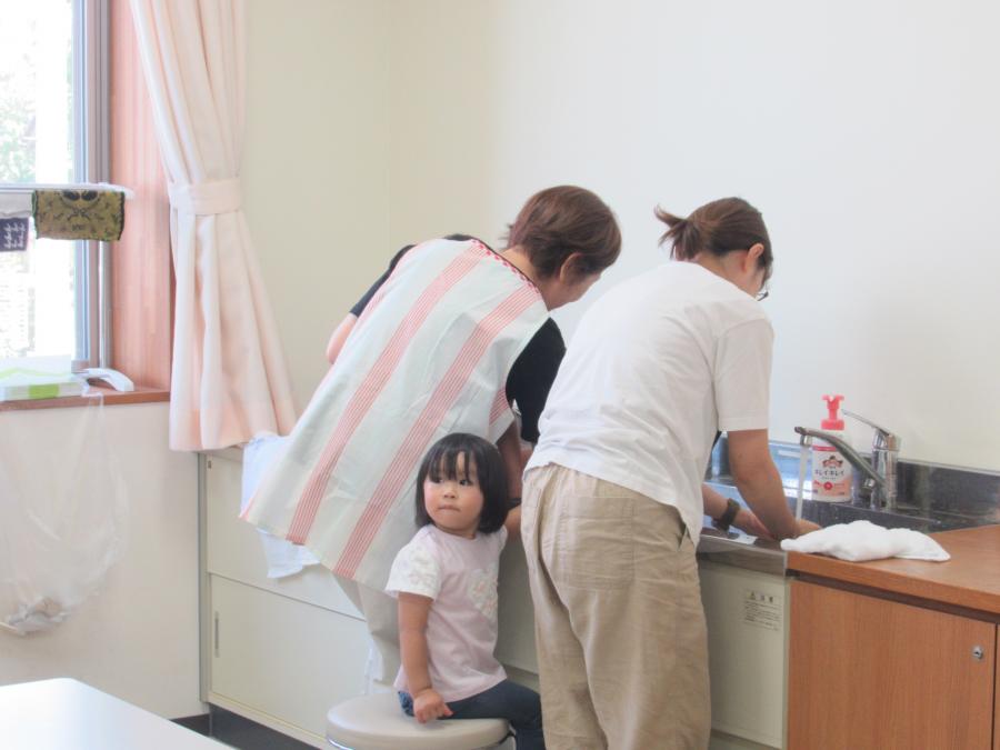 絵の具で汚れた手足を洗っている様子