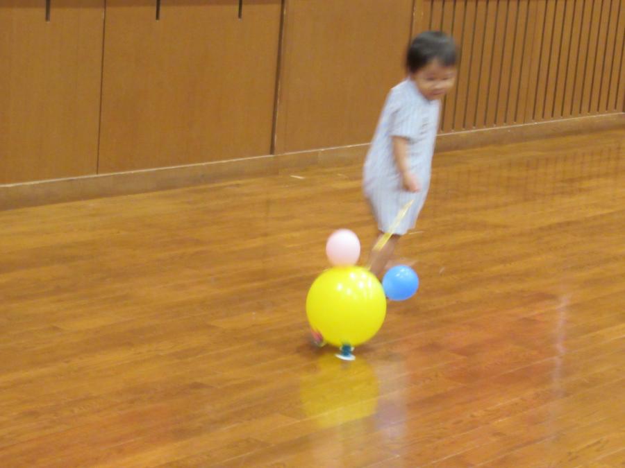 男の子がひもを引いてバルーンの動物を引っ張る様子