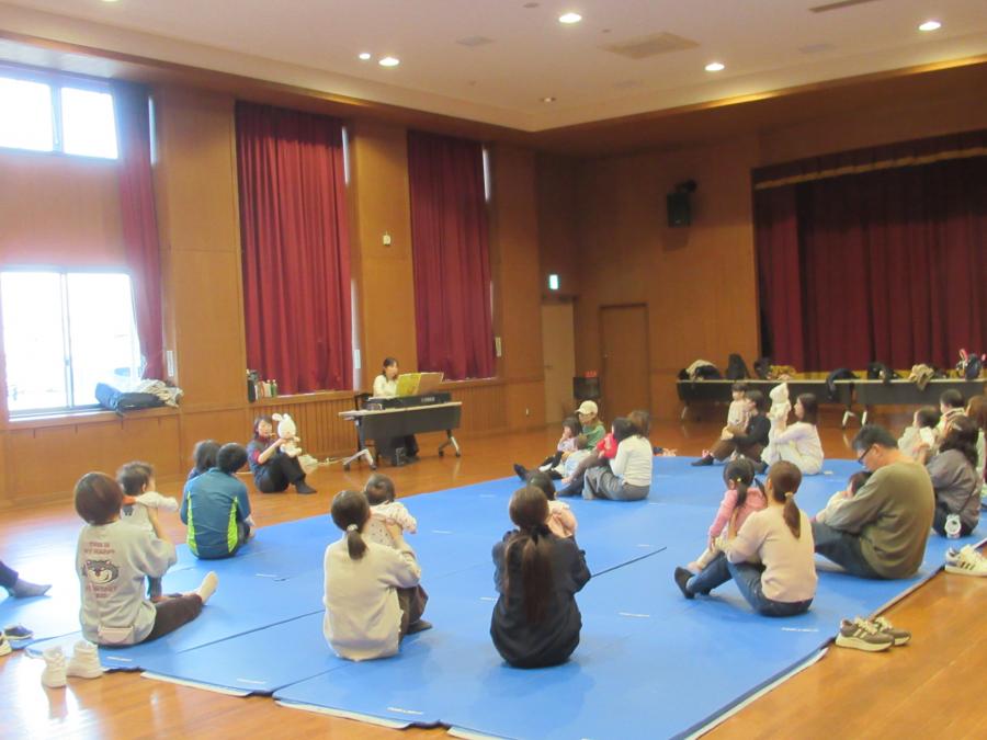 親子で座って、子どもを持ち上げる様子