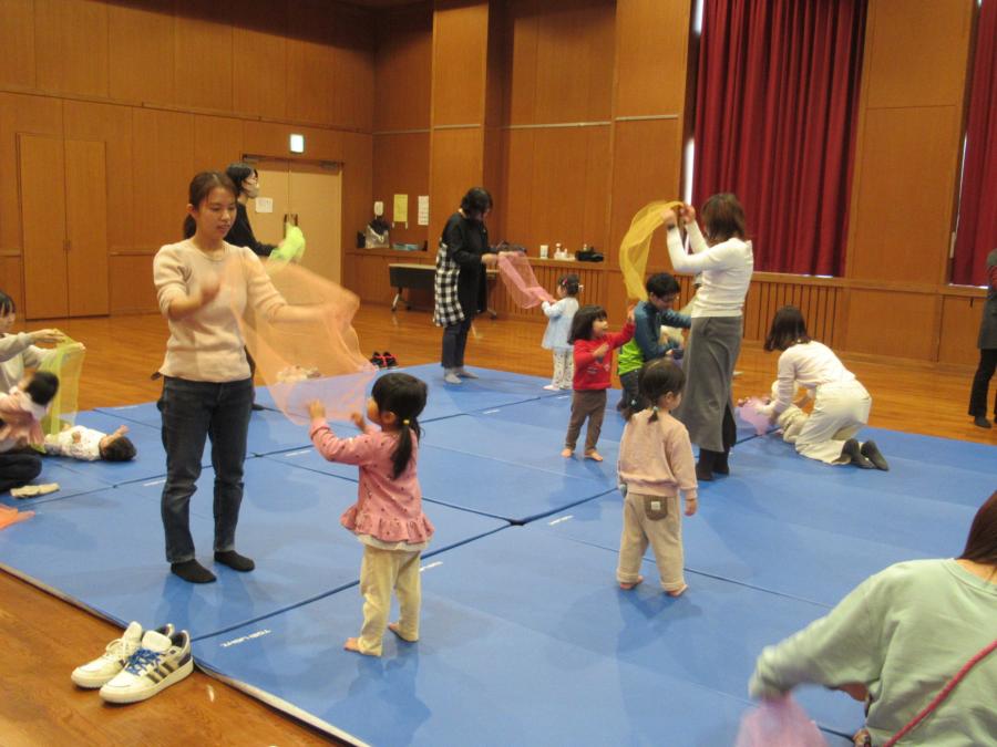 スカーフを使って親子でふわふわしての遊びをしている様子