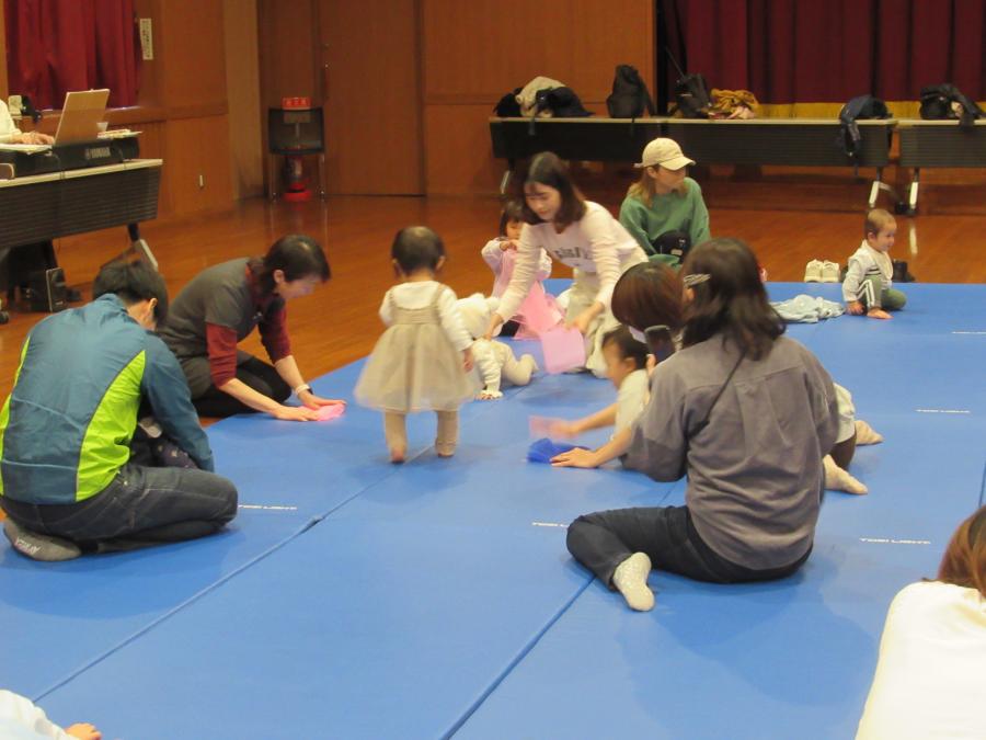 スカーフをたたんでいる親子の写真