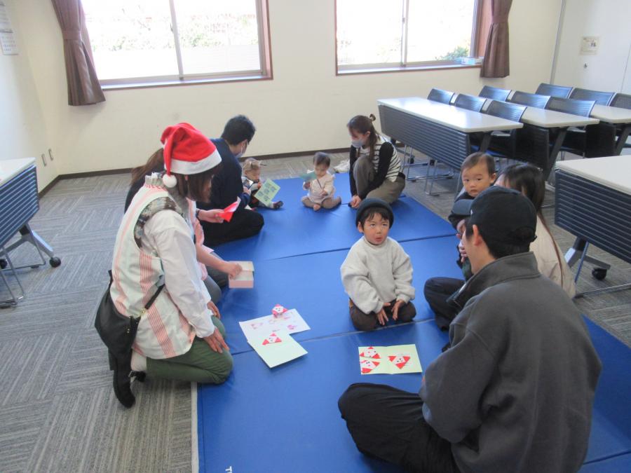 青マットの上でサンタの折り紙を折る様子