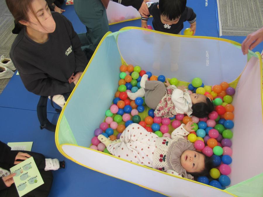 赤ちゃん二人がボールプールの中に寝ている様子