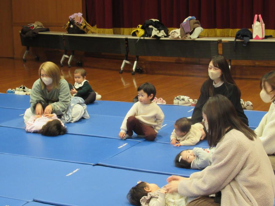 子どもが仰向けに寝て、触れ合い遊びをしている所