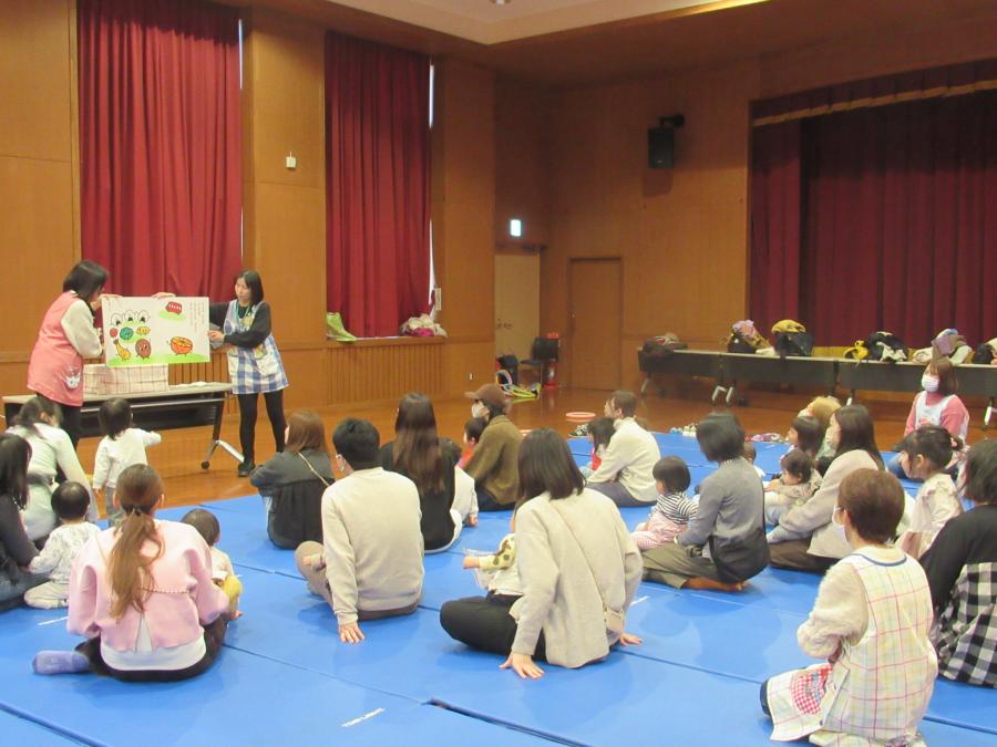 大型絵本の読み聞かせを聞く様子