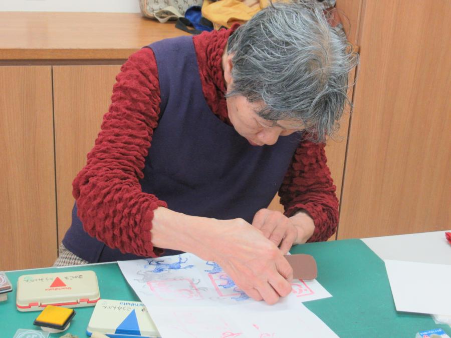 一人の参加者の女性が葉書に押している様子