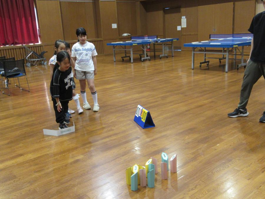 モルックを投げてスキットルに当てる様子