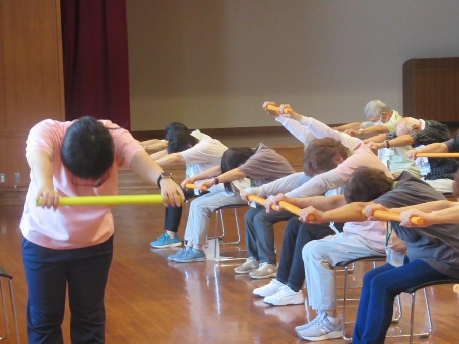 新聞棒を前に出して背中を伸ばすところ