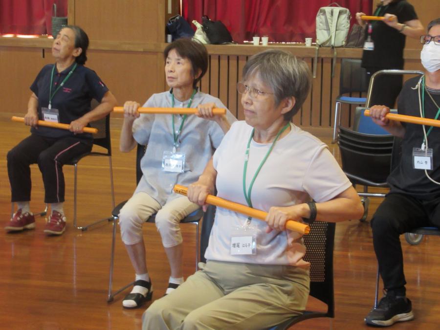 新聞棒を両手で持って手前に引く様子