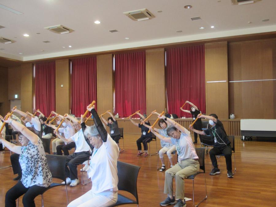 両手で上げたまま腰を曲げている様子