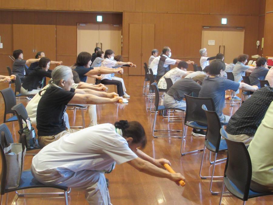 前かがみになって棒を下から上へ動かしている様子