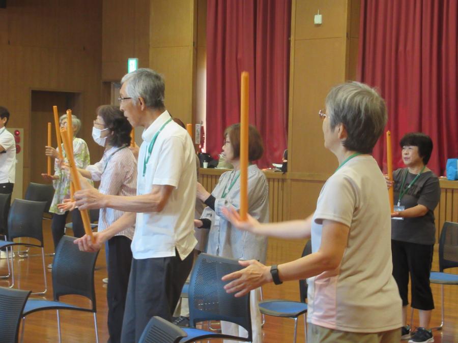 棒を立てて持ち、バランスをとる運動をしているところ