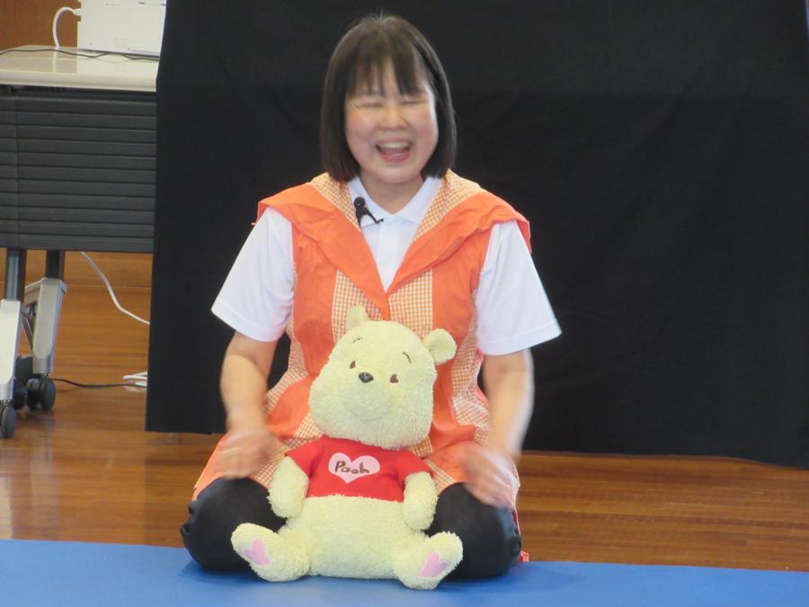 講師がぬいぐるみを子どもに見立てて、触れ合い遊びを指導する様子