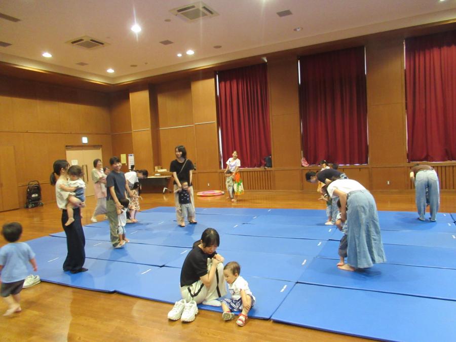 お母さんの足の甲の上に子どもが乗ってかに歩きをする様子