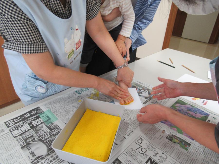 子どもの足形を絵の具を付けて取っている様子