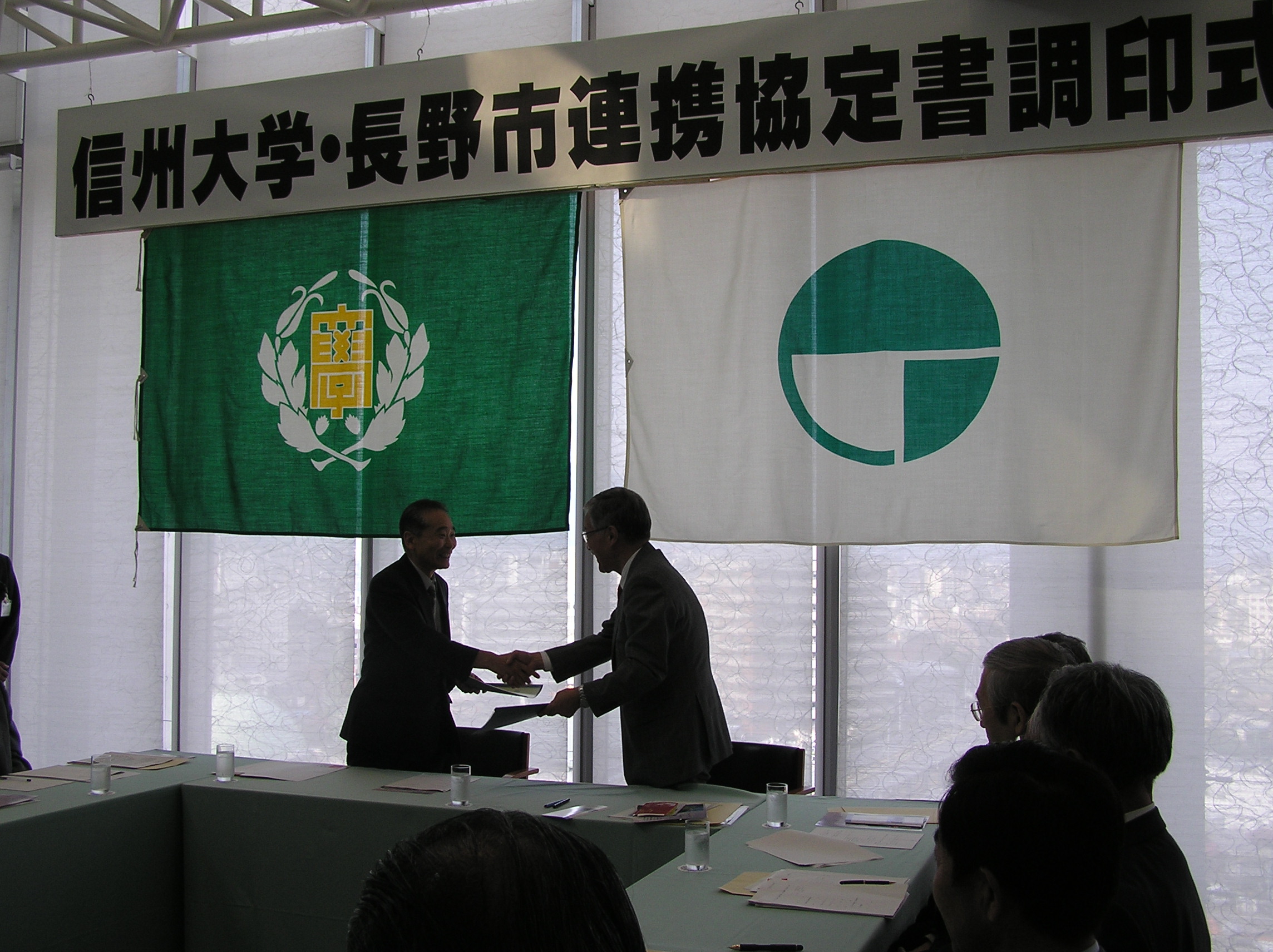 固い握手を交わす小宮山信州大学長と鷲澤長野市長